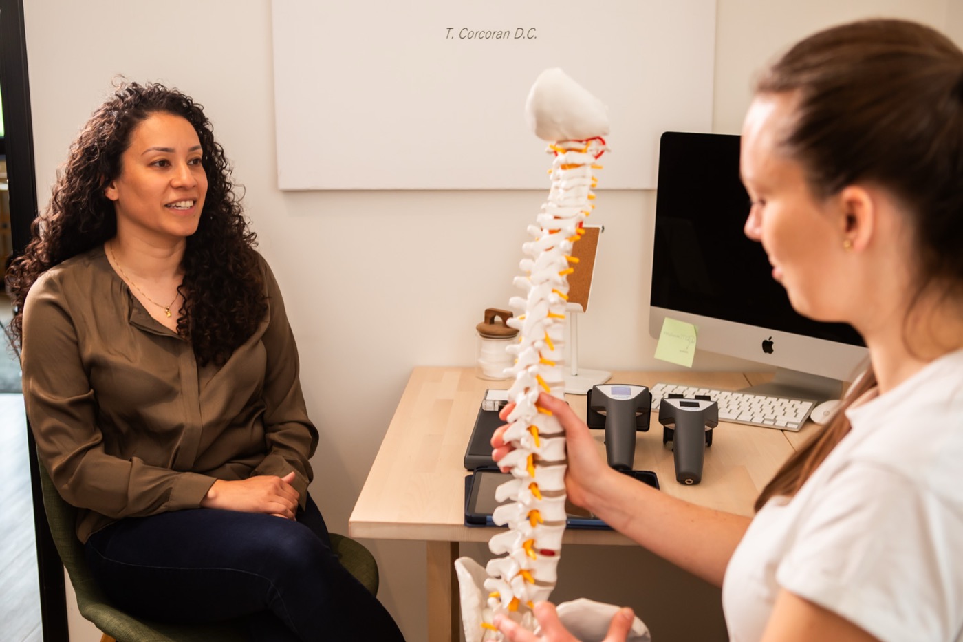 Chiropractor legt met een wervelkolommodel uit wat de scan laat zien bij TOPCHIRO Amsterdam