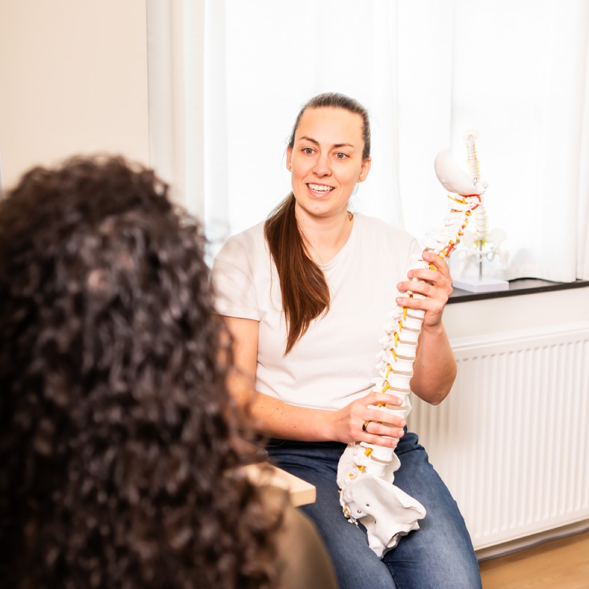 Chiropractor bespreekt het persoonlijke zorgplan met een cliënt bij TOPCHIRO Amsterdam